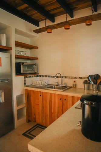 a kitchen with wooden cabinets and a sink at El Hábita CASA SELVA in Santa Teresa Beach