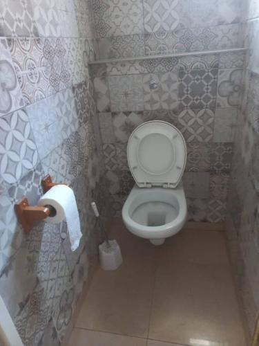 a bathroom with a toilet and a roll of toilet paper at casa maria in La Romana