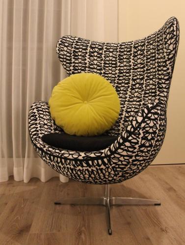 a yellow pillow on a black and white chair at Aqua Ria Boutique Hotel in Faro