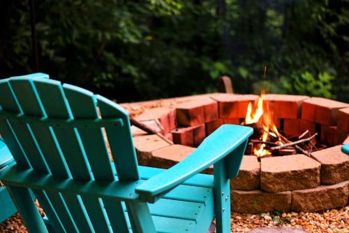een blauwe stoel naast een vuurplaats bij Cozy Cabin Retreat - Hot Tub, Fireplace & Fire Pit in Blue Ridge