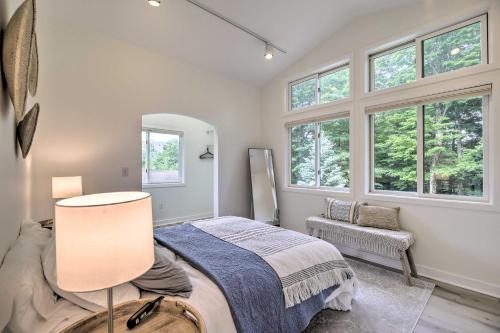 a bedroom with a bed and a chair and windows at Airy and Bright Hideaway Near Smugglers Notch! in Cambridge