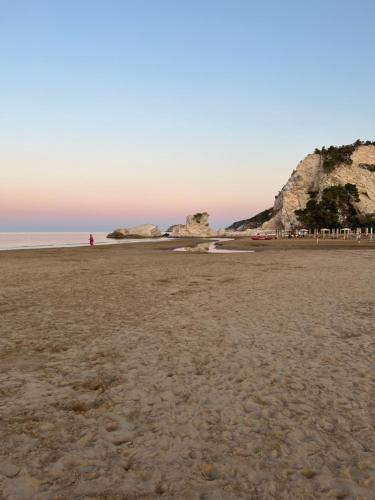 a beach with a person standing on the sand at Villa Latino in Vieste
