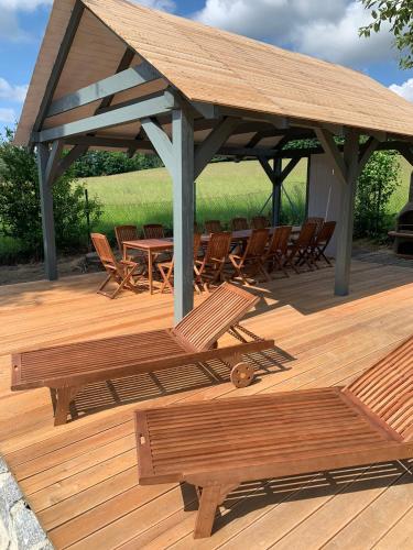 a wooden deck with chairs and a table and a pavilion at Vila Bohemia Saxon Switzerland & SPA in Šluknov
