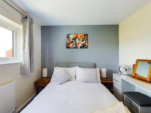 a bedroom with a white bed and a mirror at 247 Serviced Accommodation in Telford- 3BR HOUSE in Telford