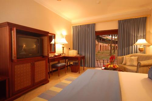 a living room with a television and a couch and a desk at Avani Pemba Beach Hotel in Pemba