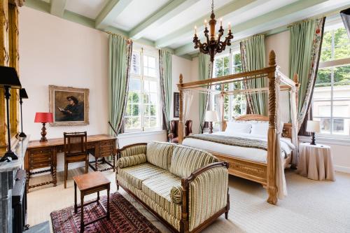 a bedroom with a canopy bed and a couch at Fortuna Spinoza in Monnickendam