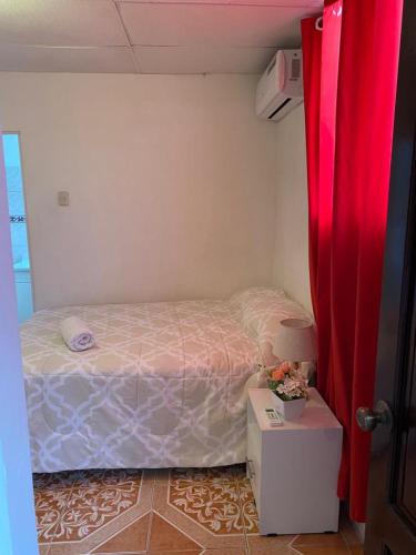 a small bedroom with a bed and a table at Los Tamarindos Posadamanabita in Portoviejo