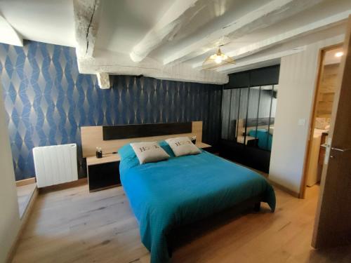 sypialnia z łóżkiem i niebieską ścianą w obiekcie Studio Centre Ville Chinon w mieście Chinon