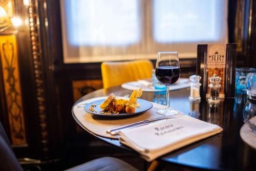 a table with a plate of food and a glass of wine at Best Western Urban Hotel in Lille