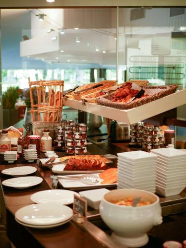 a buffet line with plates of food on a table at Best Western Le Bois de la Marche in Poitiers