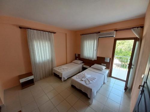 a hotel room with two beds and a balcony at Farmside OTEL in Fethiye