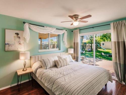 a bedroom with a bed with a ceiling fan and a window at Blue vacation house in Venice
