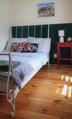 a bed in a room with a wooden floor at Podlaski Zakątek in Bereżyszcze