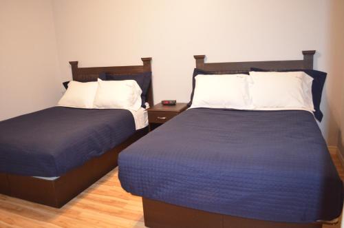 two beds in a room with two beds sidx sidx sidx at Le Citadin in Rouyn