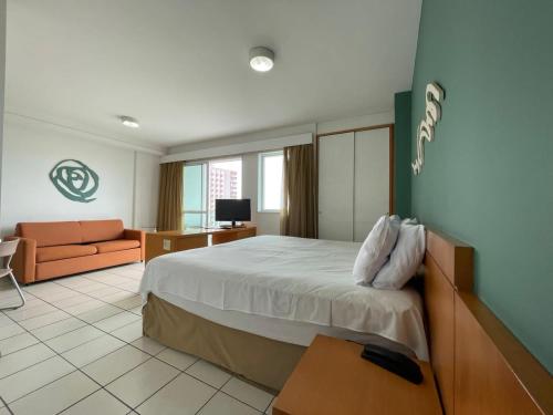 Habitación de hotel con cama y sofá en Thuis I Apê Incrível na Praia do Canto + Garagem en Vitória