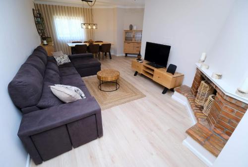 un salon avec un canapé et une cheminée dans l'établissement Diamante house com garagem privada, à Braga