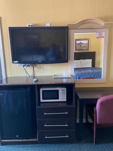 a room with a tv and a microwave on a desk at Budget Inn in Monroeville