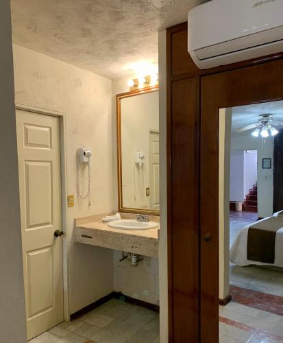 a bathroom with a sink and a mirror at Hotel Inn Galerias in Aguascalientes