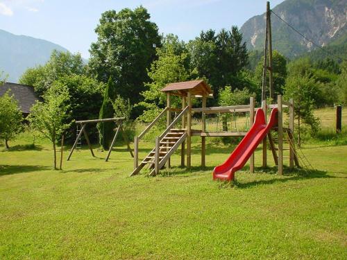 a playground with a red slide and a swing at Appartement zur Post in Ferlach