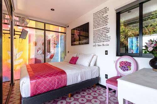 a bedroom with a bed and a desk and window at Cabane Container Hotel - ADULTS ONLY in Puerto Escondido