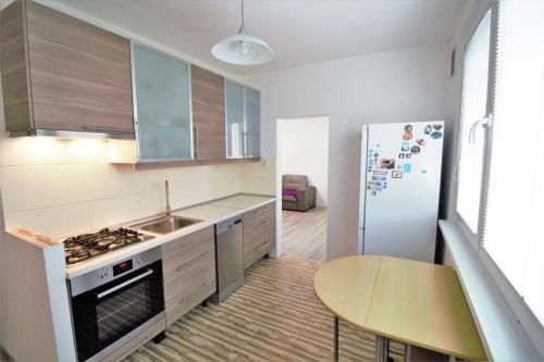 a kitchen with a stove and a sink and a refrigerator at Cozy, bright room with free parking in Bratislava