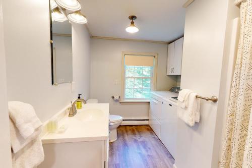 a white bathroom with a sink and a toilet at Falling Pines in Readfield