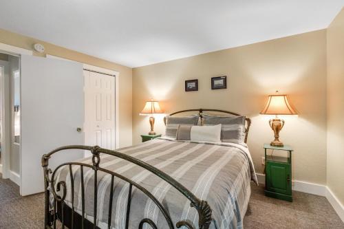 a bedroom with a bed with two lamps on two tables at Cake by the Ocean in Clinton