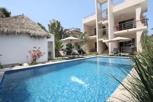 a swimming pool in front of a villa at Hotel Suites Del Mar in La Manzanilla