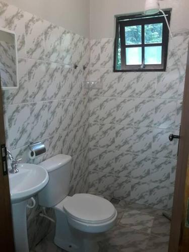 a bathroom with a toilet and a sink at Casinha nas montanhas in Gonçalves