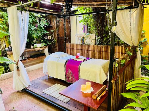 a room with a bed and a table with a candle at Hacienda Boutique B&B and Spa Solo Adultos in Cozumel