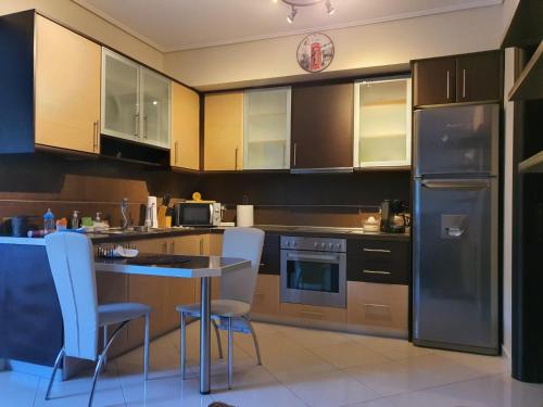 - une cuisine avec des placards en bois, une table et des chaises dans l'établissement Quite, Fully equipped apartment in Artemis, à Artemi