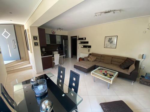 a living room with a couch and a table at Quiet apartment in Artemis, Athens Airport in Artemida