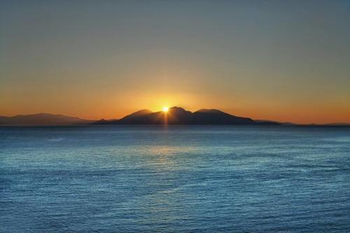 a sunset over a large body of water at Κastro Ηotel in Agios Kirykos