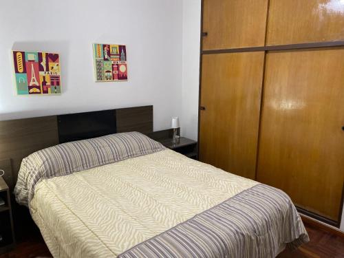 - une chambre avec un lit et une armoire en bois dans l'établissement Alto Belgrano II, à Mendoza