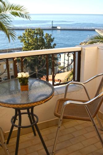 a table and chairs on a balcony with the ocean at Κastro Ηotel in Agios Kirykos