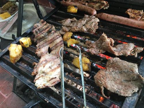 a bunch of meat and other foods on a grill at Finca La Belleza-Villeta in Villeta