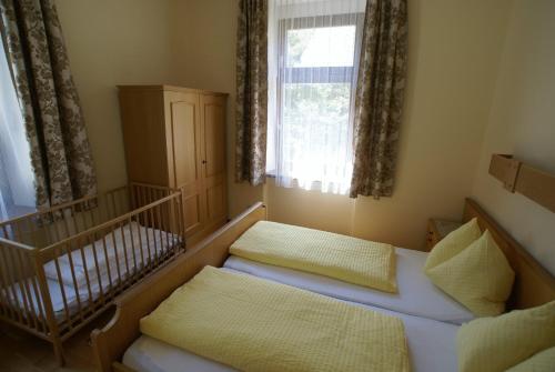 a small room with a bed and a crib at Appartement zur Post in Ferlach
