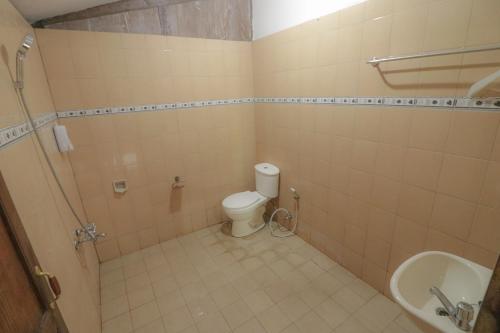 a bathroom with a toilet and a sink at Kampoeng Semar Borobudur in Magelang