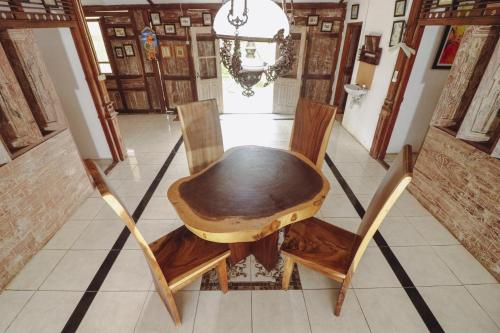 a wooden table and two chairs in a room at Kampoeng Semar Borobudur in Magelang