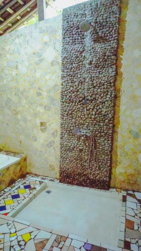 a bathroom with a shower in a wall with mosaic tiles at Kampoeng Semar Borobudur in Magelang