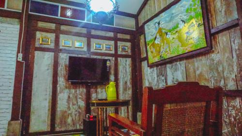 a living room with a tv and a wooden wall at Kampoeng Semar Borobudur in Magelang