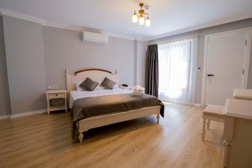 a bedroom with a large bed and a window at İcarus Alaçatı in Çeşme