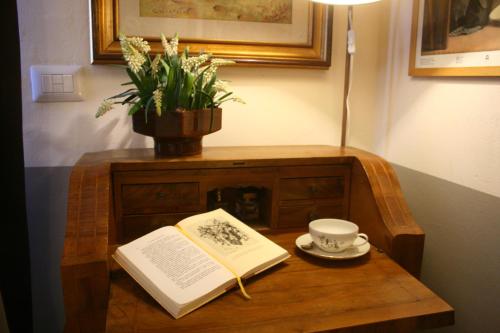 ローマにあるLe Stanze dei Cardinaliの本と杯と植物を持つテーブル