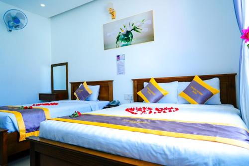 a bedroom with two beds with red flowers on them at Côn Sơn Victory Hotel in Con Dao