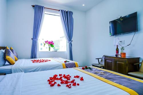 a hotel room with two beds with red flowers on them at Côn Sơn Victory Hotel in Con Dao