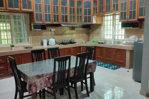 a large kitchen with a table and chairs in it at 3R3B in Kota Bharu near Datu River in Kota Bharu