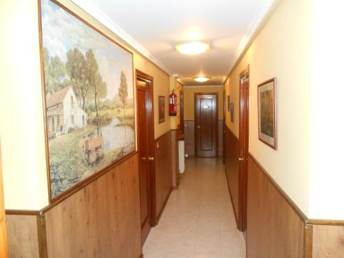 a hallway in a nursing home with paintings on the walls at Hostal Restaurante El Abuelo in Trobajo del Camino