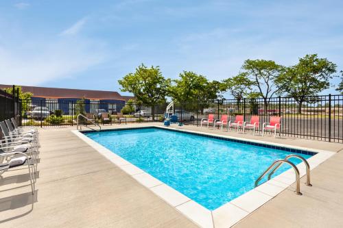 a swimming pool at a hotel with chairs around it at Super 8 by Wyndham Lenexa Overland Park Area/Mall Area in Lenexa