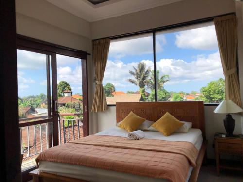 a bedroom with a bed and a large window at Run House B&B in Ubud
