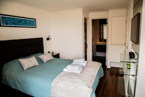 a bedroom with a bed with towels on it at Moderno y Estiloso Excelente Ubicación, Las Condes in Santiago